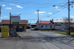 The feed mill is built right next to a railroad track and intersection.