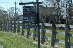 For sale signs next to farm land, but not the house. 