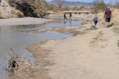 See people crossing the creek to get to the path into the canyon. This is the only access point and is not accessible if there is flooding.