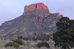 The tall rock formation behind us is lit up by the setting sun